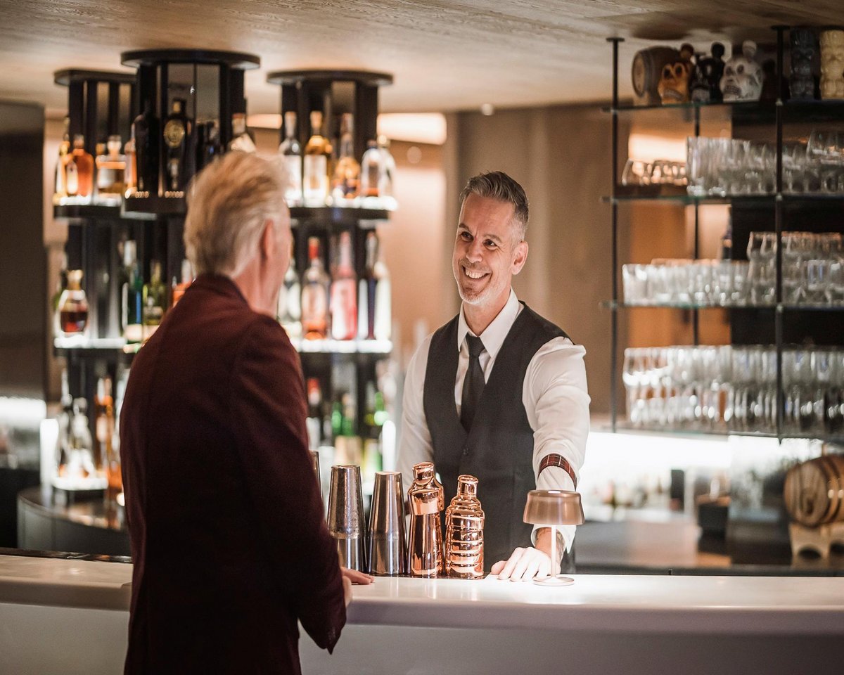 Barkeeper und Gast an der Bar eines Winkler Hotels