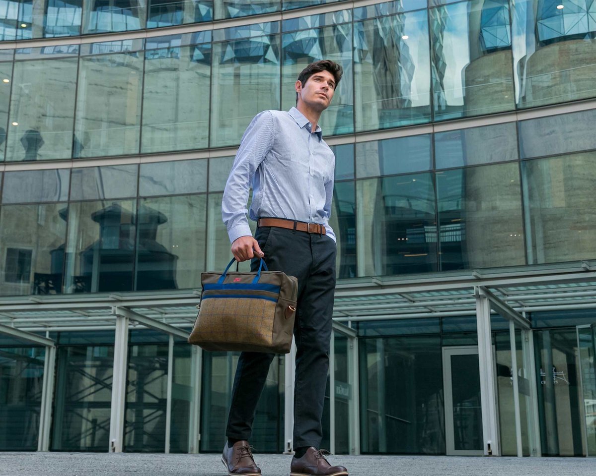 Model mit Tasche von Carlitos vor einem Glasbau