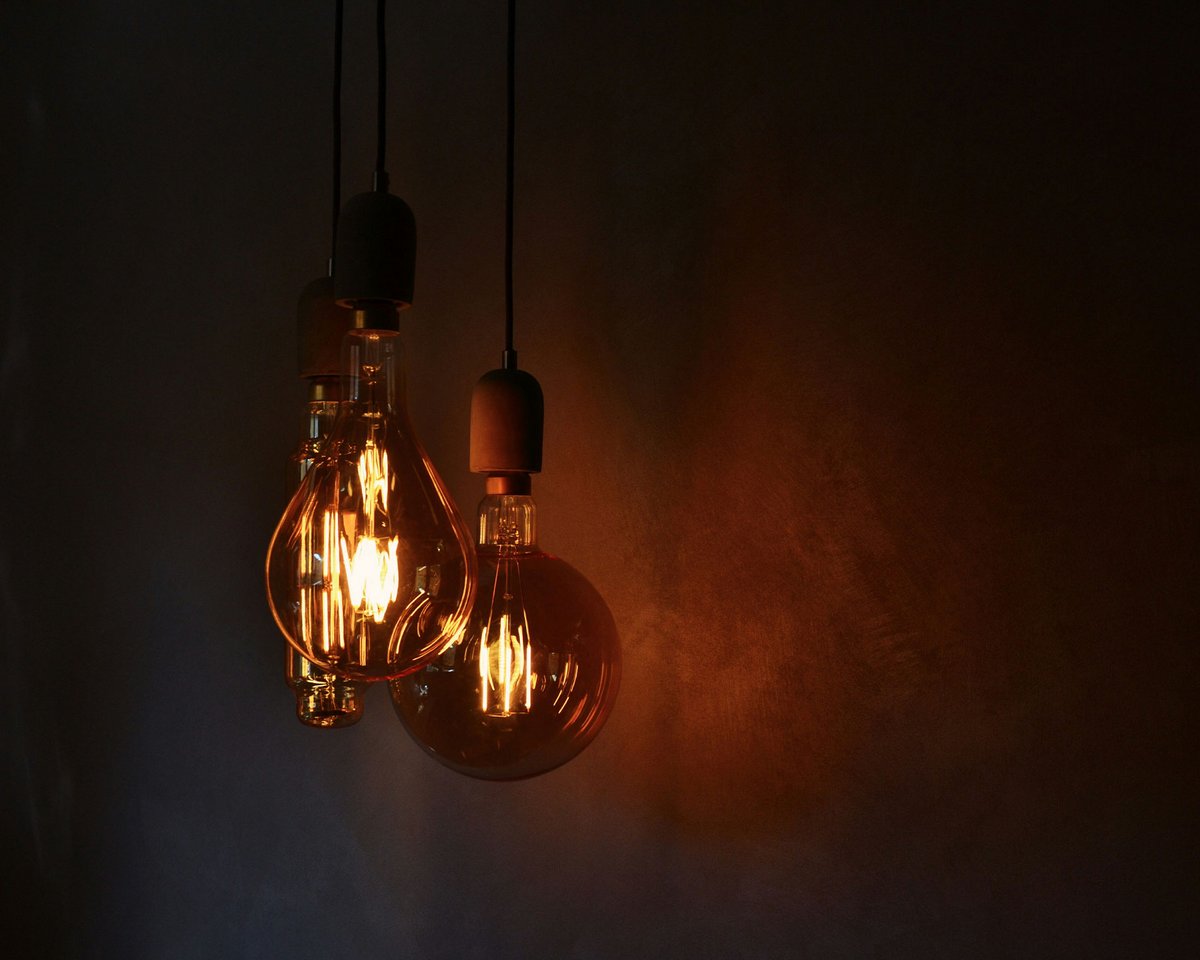 Glühbirnen mit warmem Licht vor dunkler Wand
