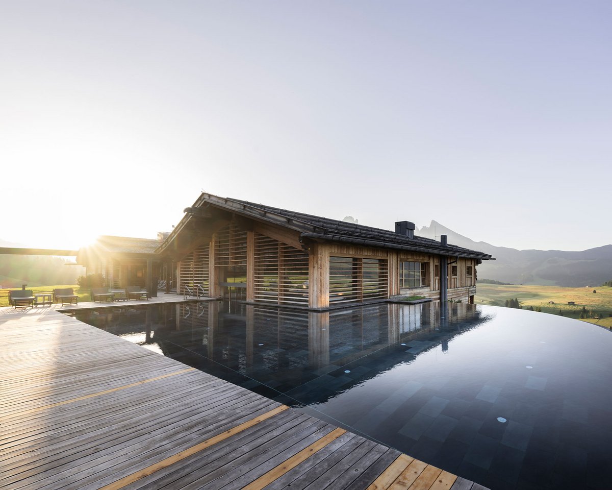 Naturpool und Holzchalet der ADLER Lodge ALPE